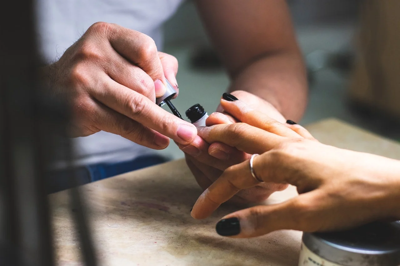Nail artiste du Studio Klaw en pleine pose de vernis